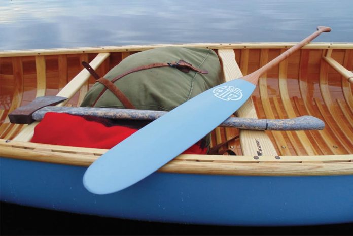 painted paddle sitting across canoe