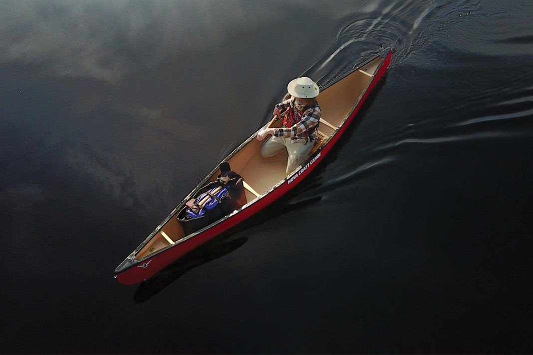 Ariel view of a man paddling canoe on a lake