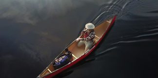 Ariel view of a man paddling canoe on a lake