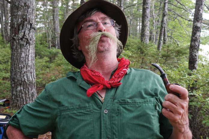 man in woods with a fake moustache