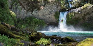 man kayaking off a waterfall