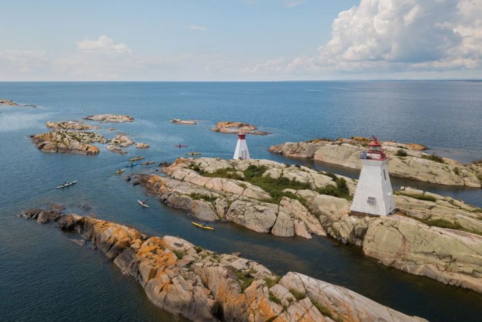 lighthouses on an island surrounded by sea kayaks