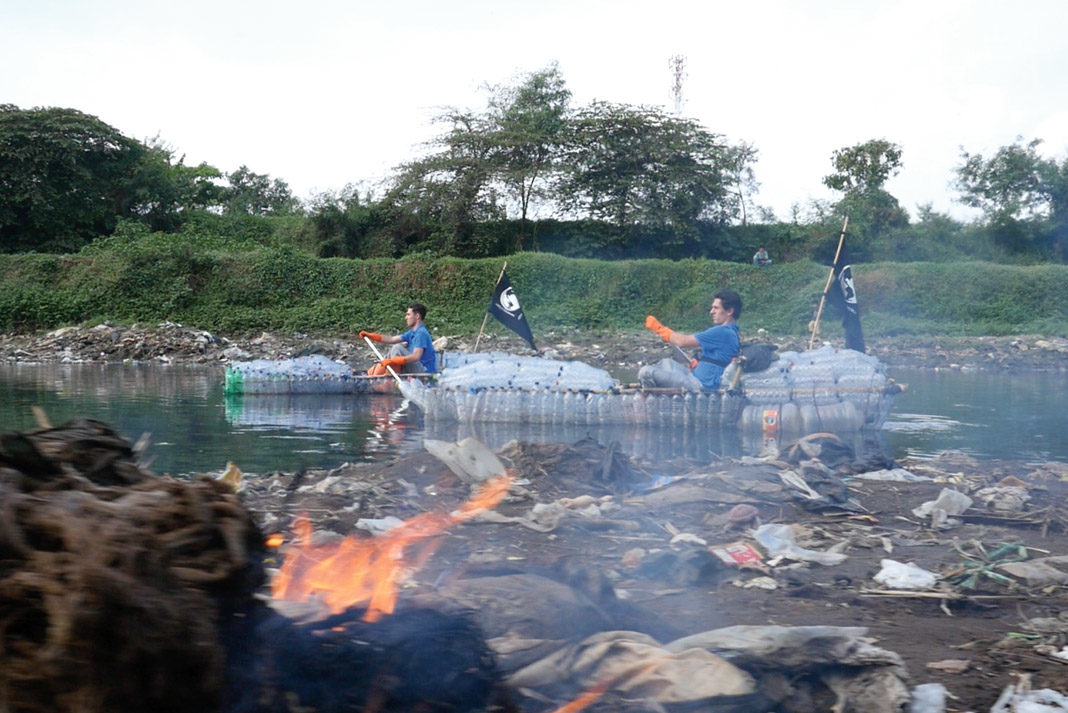 two men in kayaks made out of trash
