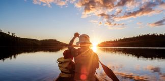 woman and child paddling into sunset stress free