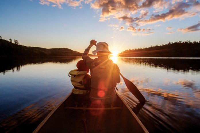 woman and child paddling into sunset stress free