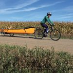 Canoe Review: Abitibi Saugeen 16.6 Woman on a bike shuttling a Bluewater Saugeen canoe