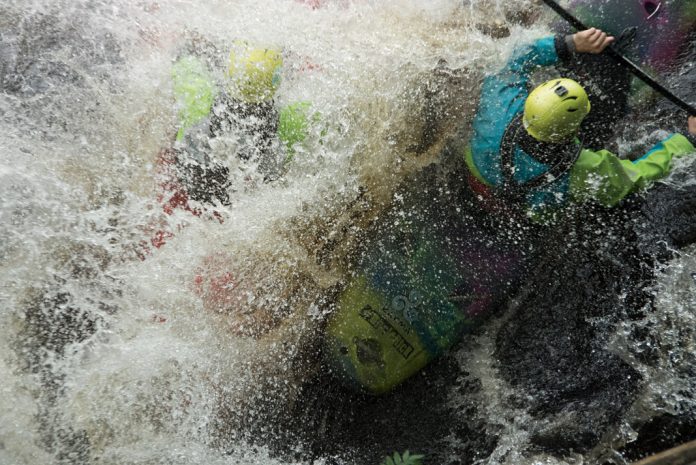 two kayakers crashing in whitewater