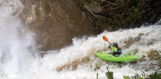 skilled kayaker dropping off a waterfall