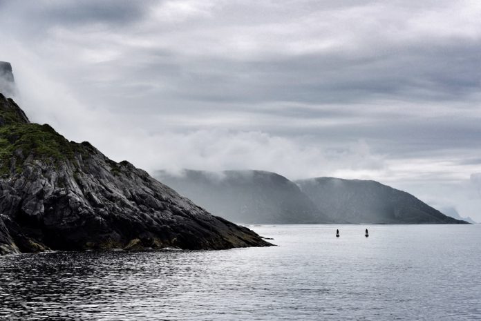 two standup paddle-boarders in the distance on a lake