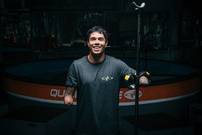 man with amputated arms smiling with paddle board paddle