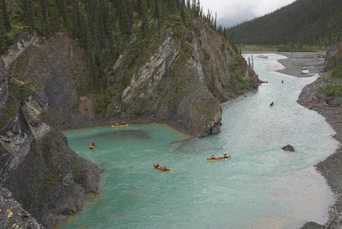 several canoes doing a tandem trip down a river