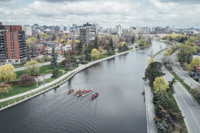 several large canoes paddling through city