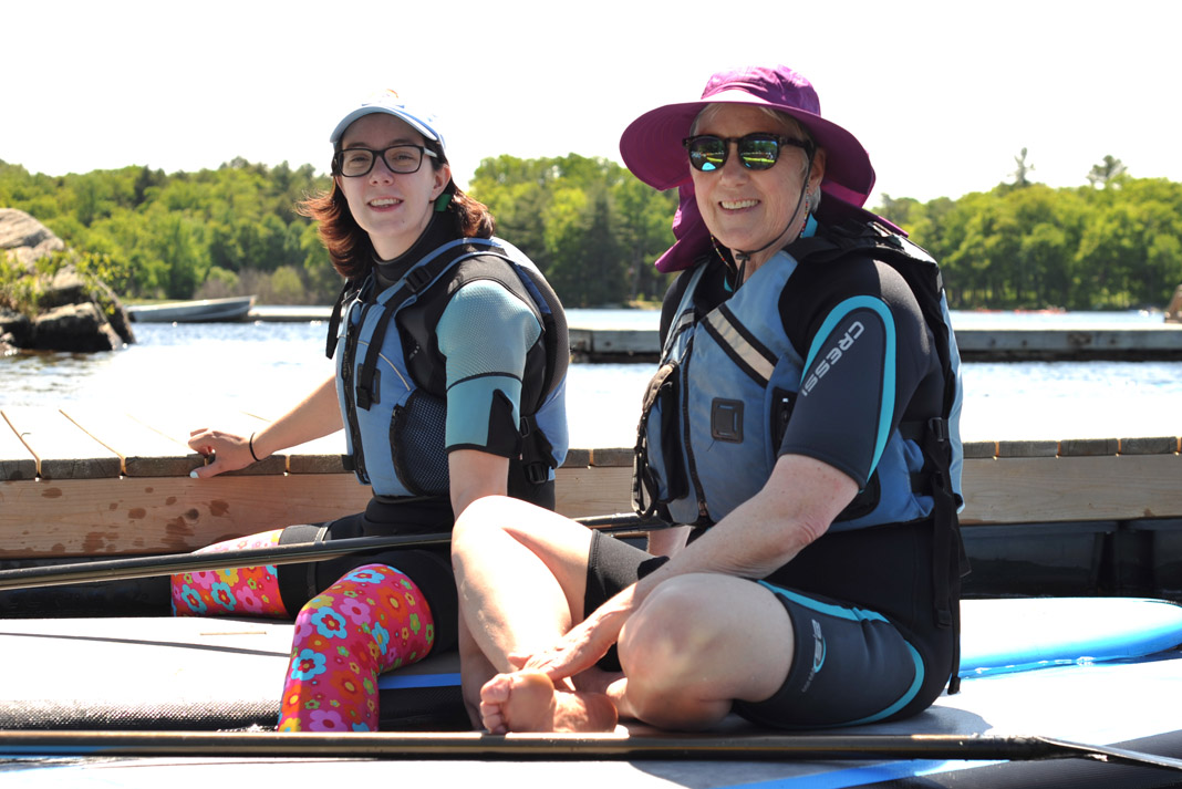 two women wearing paddling gear on boats