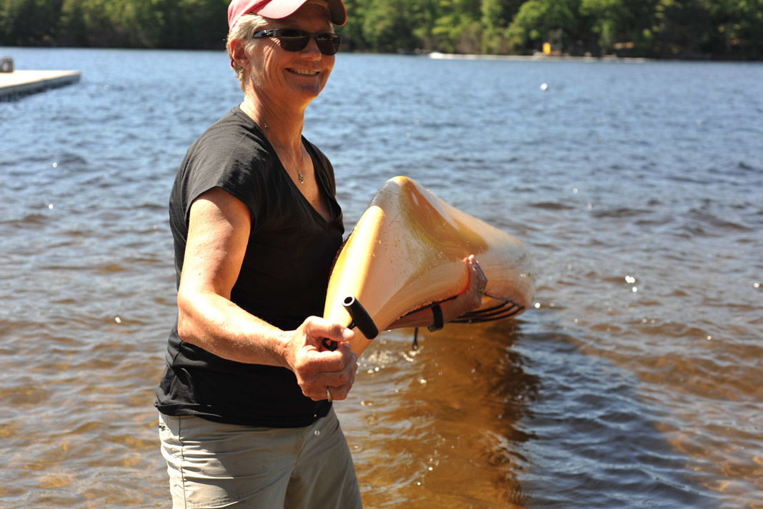 woman with an upside down sea kayak