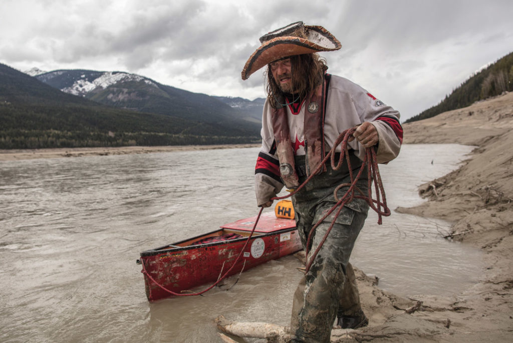 Mike Ranta pulling his canoe across muddy waters