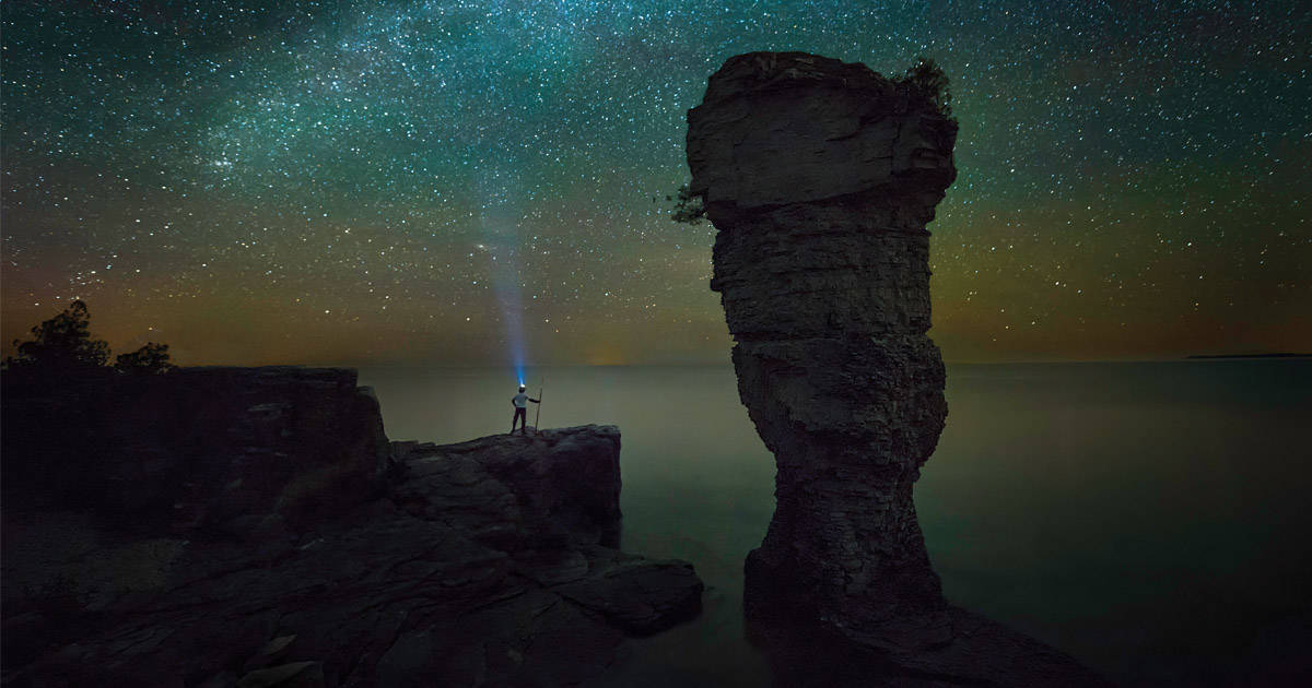 person secluded staring up at the sea of stars