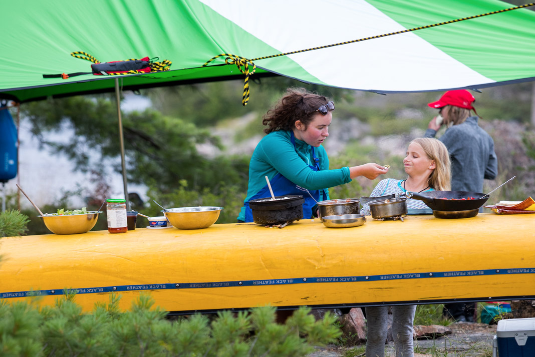 two girls eating off a canoe