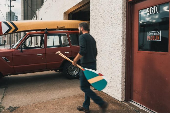 man walking towards his canoe and truck