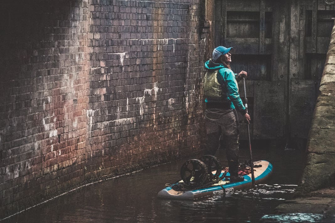 paddleboarder surrounded by city walls
