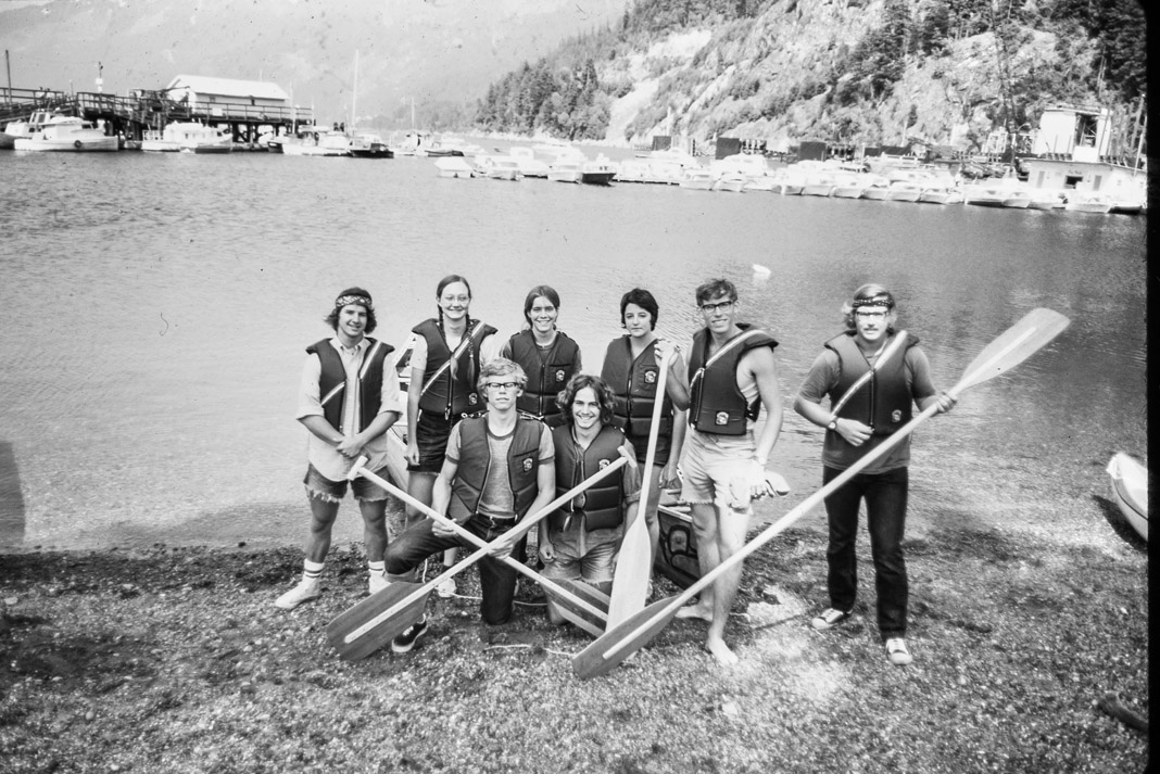 group of people wearing life jackets and holding paddles