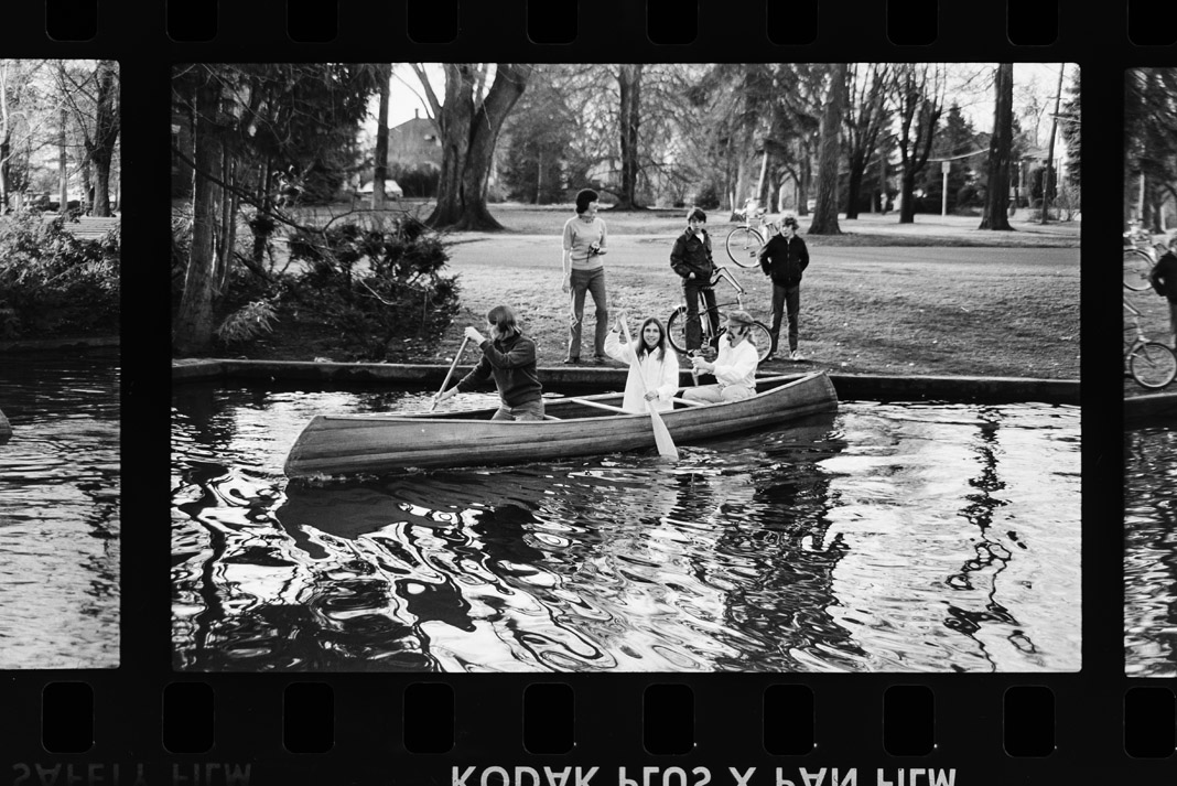 people paddling a canoe in black and white