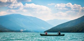two people paddling a canoe on Lake Revelstoke surrounded by mountains