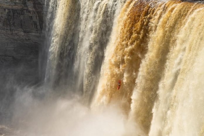 Bren Orton kayaking over Alexandra Falls in Northern Canada