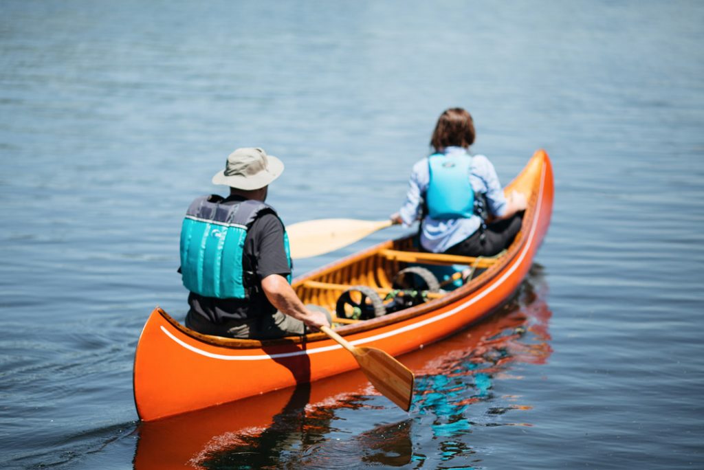 Two people paddling in wooden canoe