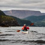 The Real Problem With Kayak Rudders Man paddles a kayak in the water
