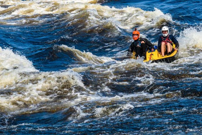 two men pedal boating in whitewater