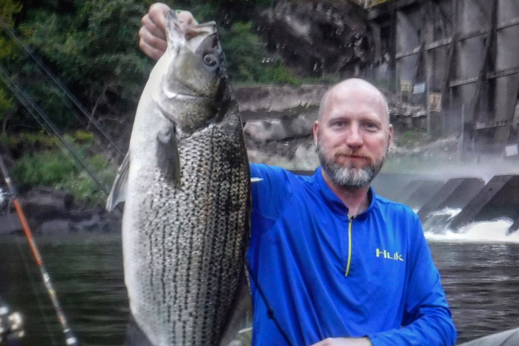 man holding a large striped bass