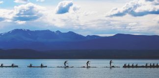Paddlers in the midst of Yukon River Quest with beautiful mountains all around