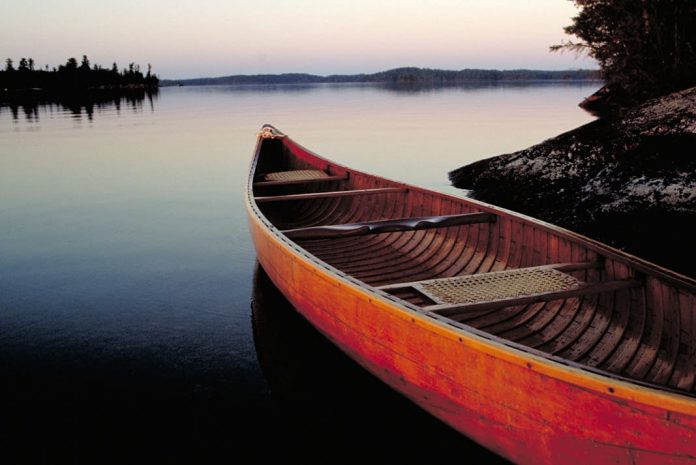 a canoe sitting on a lake ready to be launched