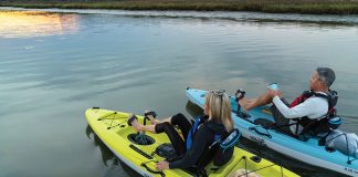 A young couple are seen pedalling around each in a Hobie Mirage Passport kayak
