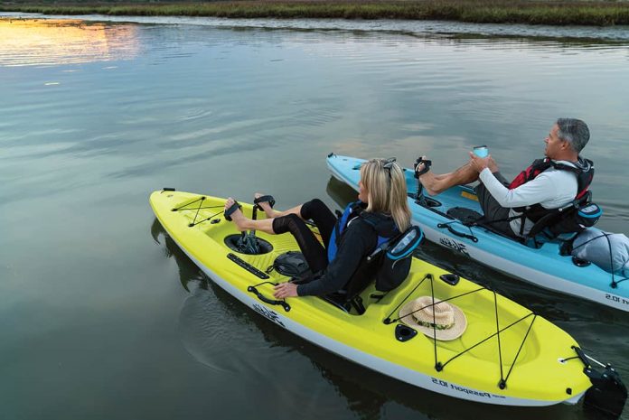 A young couple are seen pedalling around each in a Hobie Mirage Passport kayak