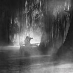 Expert Tips On How To Photograph Swamps From A Kayak a man on his kayak photographing a swamp in Louisiana's Atchafalaya Basin