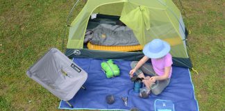 person sits with a selection of ultralight kayak camping gear