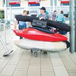 How To Fly Hassle-Free With A Kayak two men in the airport preparing to fly with their kayaks