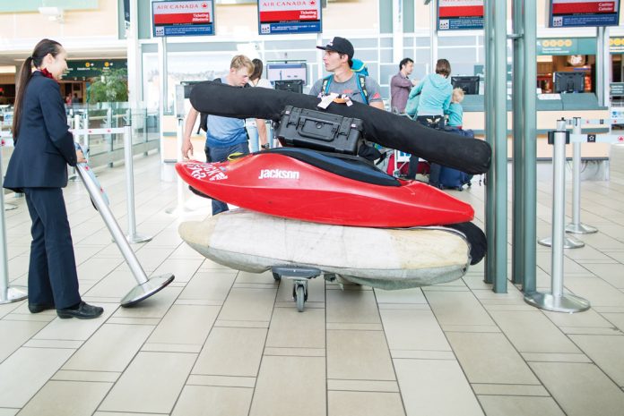 two men in the airport preparing to fly with their kayaks