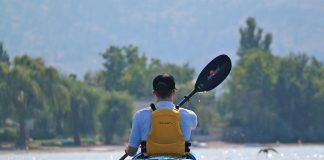 man paddles in a Delta Kayak wearing a Salus PFD