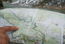 Pointing at a map while planning a kayak expedition