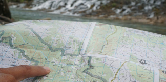 Pointing at a map while planning a kayak expedition