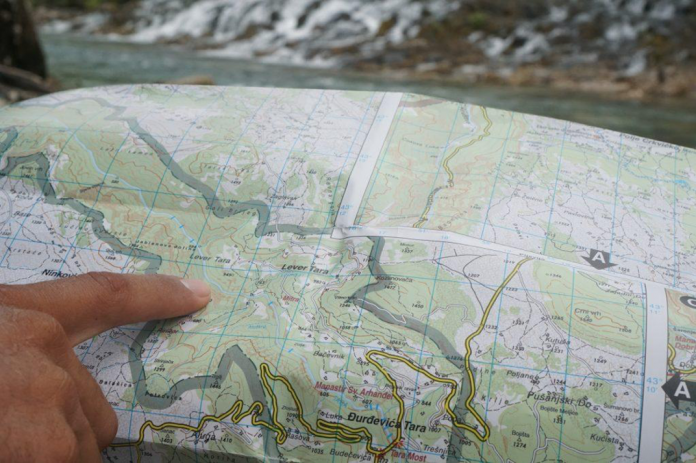 Pointing at a map while planning a kayak expedition