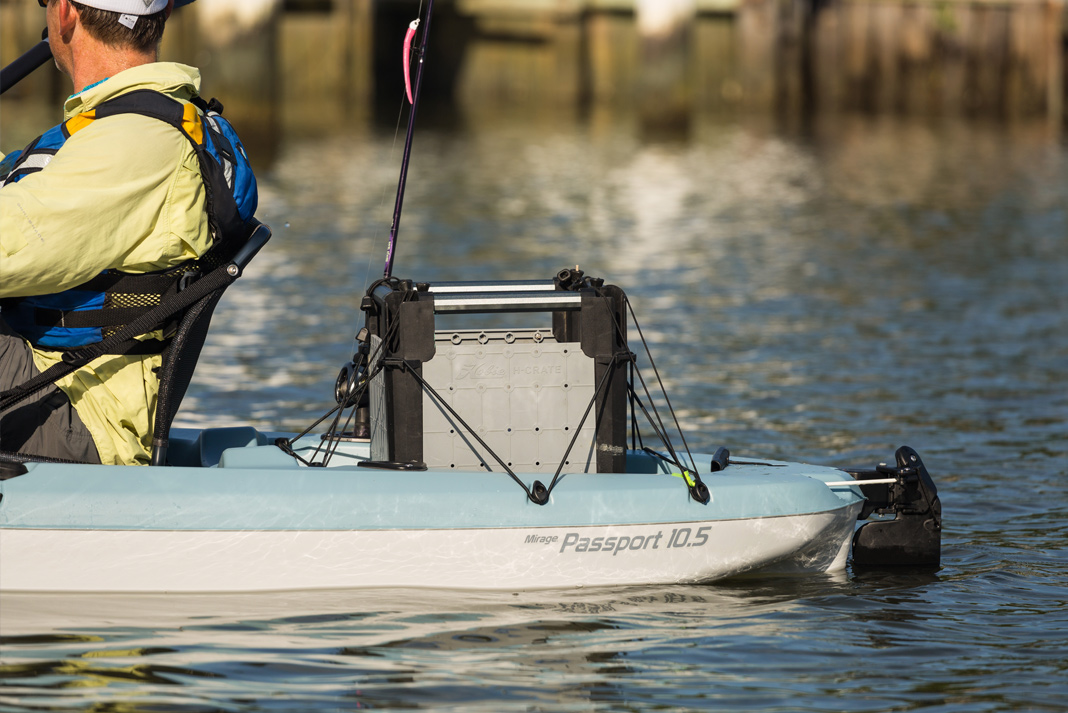 man paddles a Hobie Mirage Passport 10.5 fishing kayak with crate in the back