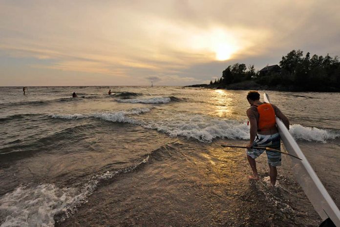 Man walking with SUP into the water