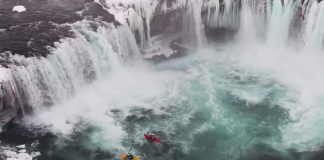 Kayakers at bottom of waterfall