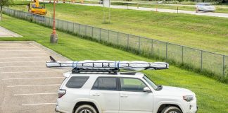 Paddleboard in bag on roof rack of vehicle