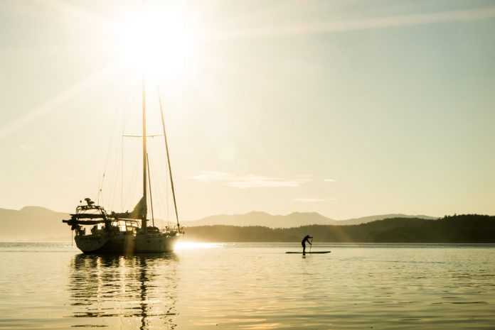 Sailboat and paddleboarder on the water
