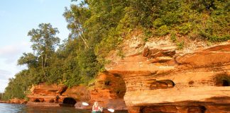 Person kayaking near shore in Apostle Islands