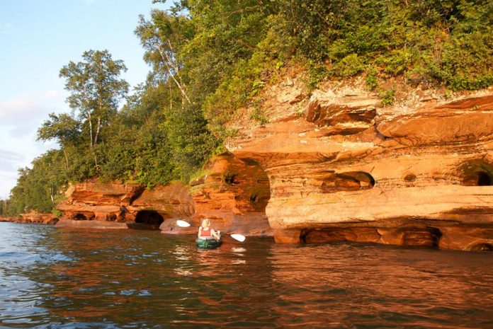 Person kayaking near shore in Apostle Islands